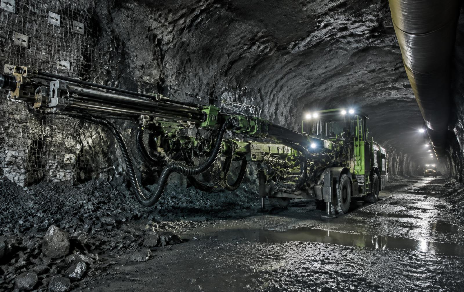 Modern drilling machinery operating in a reinforced underground mine tunnel